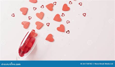 Video Of Champagne Glass Spilling Red Heart Shapes On White Background