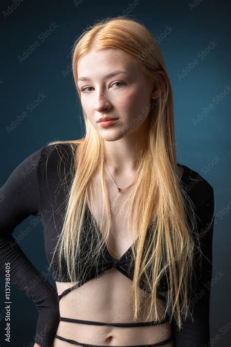 Portrait Of A Blonde Woman With Freckles In A Sexy Top And Denim Shorts In A Studio Stock Photo
