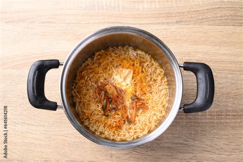 Korean Spicy Instant Noodles Soup With Kimchi And Egg In Hot Pot On Wooden Background Table Top