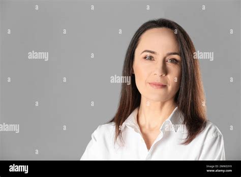 Portrait Of Beautiful Mature Woman On Grey Background Space For Text