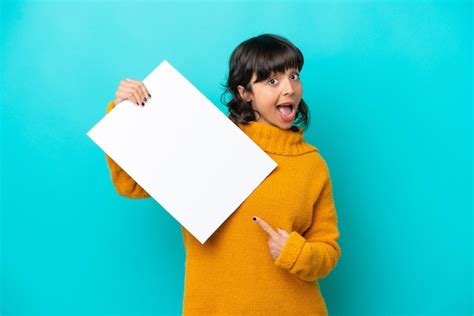 Joven Latina Aislada De Fondo Azul Sosteniendo Un Cartel Vac O Con Expresi N Feliz Y Apunt Ndolo