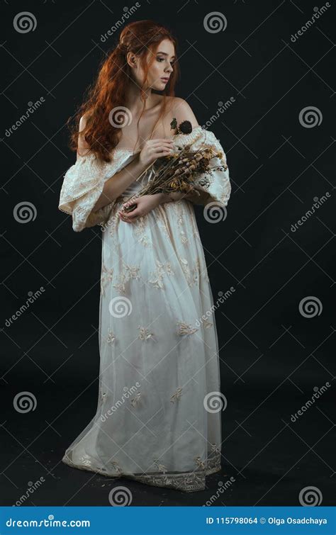 Giovane Donna Dai Capelli Rossi In Un Vestito D Annata Dall Oro Con Le Spalle Nude Con Un Mazzo