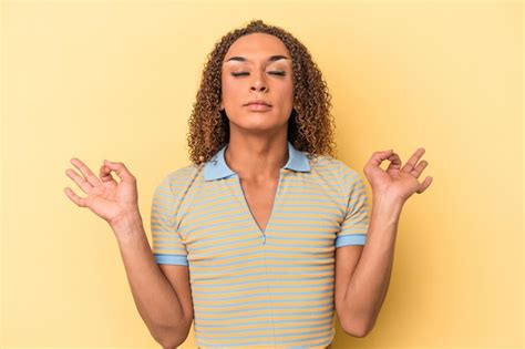 Jovem transexual latina isolada em fundo amarelo relaxa após um duro dia de trabalho ela está