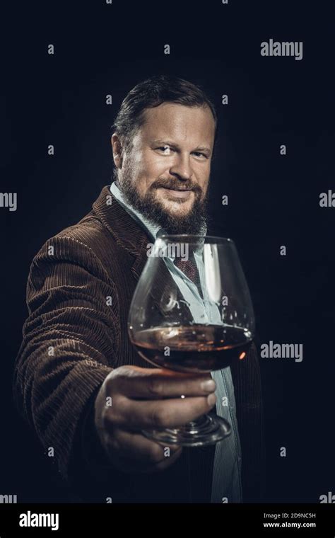 Stylish Bearded Man Dressed In Brown Jacket With Glass Of Whisky Studio