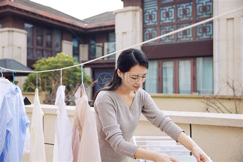 在室外晾晒衣服的女性高清图片下载 正版图片502384025 摄图网