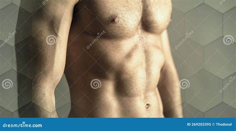 Muscular Man Torso Bodybuilder Is Posing In The Colorful Neon Light With Naked Muscular Torso