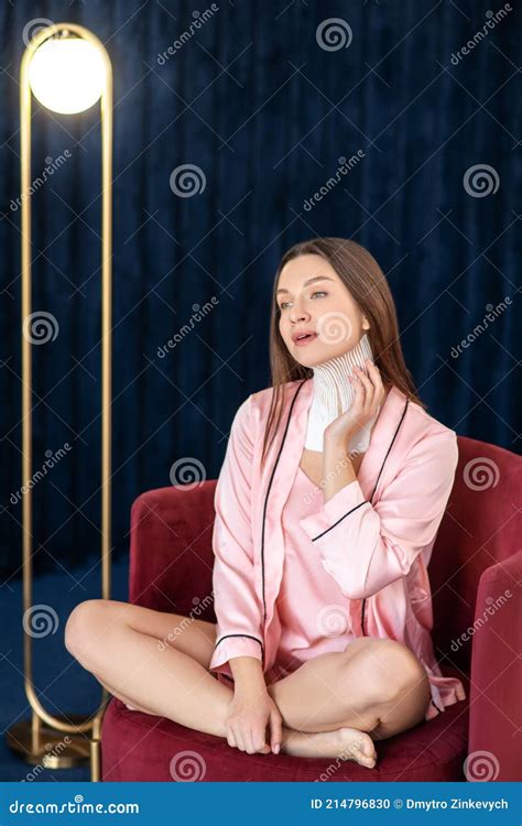 Jeune Femme En Lingerie Rose Et Avec Des Cassettes Sur Le Cou Photo