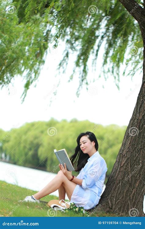 Fille Chinoise Lisant Un Livre Sous L Arbre La Belle Jeune Femme Blonde Avec Le Livre S Asseyent
