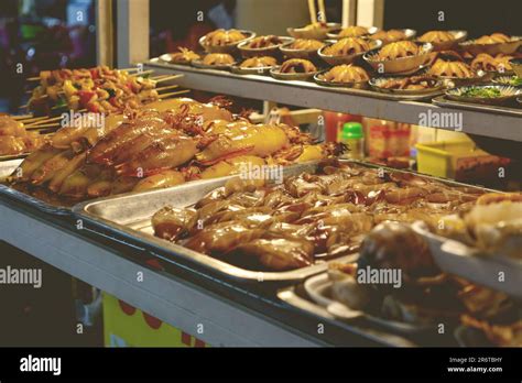 An Outdoor Food Cart At A Busy Night Market In An Urban Setting Stock