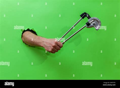 A Man Holds A Pipe Bender Tool On A Green Background Stock Photo Alamy