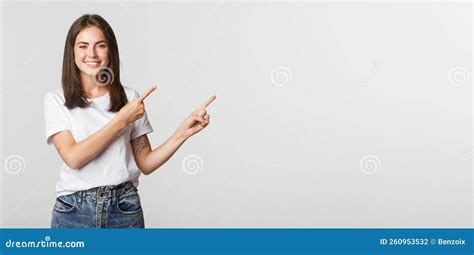 Attractive Smiling Brunette Girl Pointing Fingers Upper Right Corner Showing Logo Stock Photo