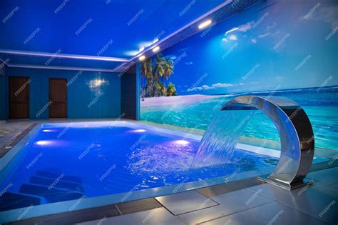 Premium Photo | A modern large indoor pool with blue lighting and a ...