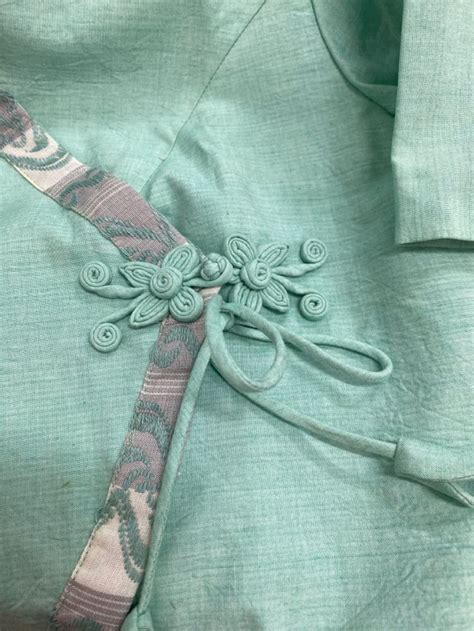 A Green Shirt With An Intricate Design On The Front And Back Tied To A