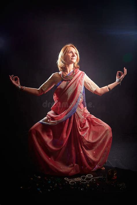 A Beautiful Adult Skinny European Blonde Woman In A Beautiful Indian Sari Does Yoga Exercises On