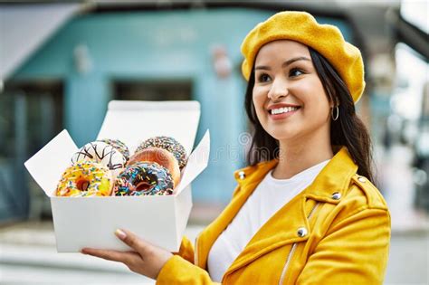 Jovencita Latina Sonriendo Feliz Caja De Espera Con Coloridas Donuts En La Ciudad Foto De
