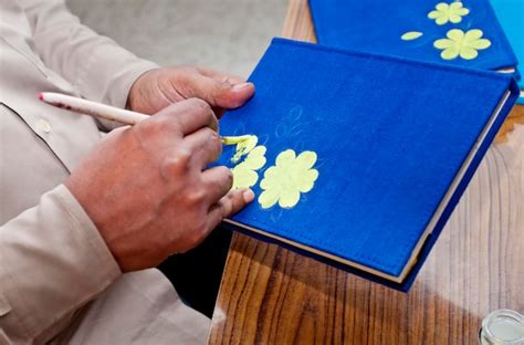 Premium Photo A Handicraft Artist Is Painting On A Handmade Book