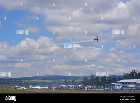 Small Plane Flying Close To The Ground At Low Altitude With Smoke At