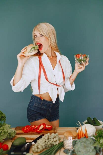 Belle Fille Fait Une Salade Blonde Sportive Dans Une Cuisine La Femme Choisit Entre Un
