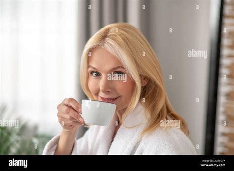 Good Looking Blonde Woman Having Tea And Looking Balanced Stock Photo Alamy