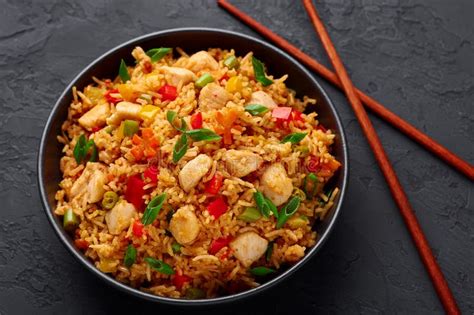 Schezwan Chicken Fried Rice In Black Bowl At Dark Slate Background