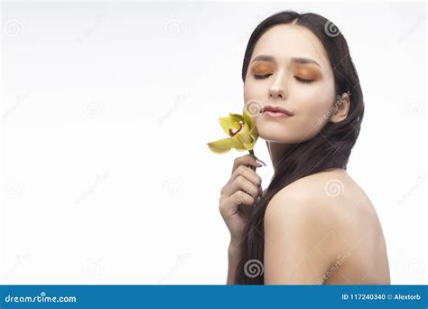 Uma Menina Moreno Bonita Dos Ombros Do Nude Guarda Sensualmente Um Flowe Foto De Stock Imagem