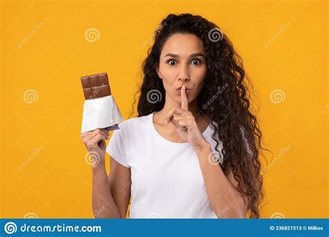 Hambrienta Latina Sosteniendo Chocolate En El Estudio Imagen De Archivo Imagen De Latino