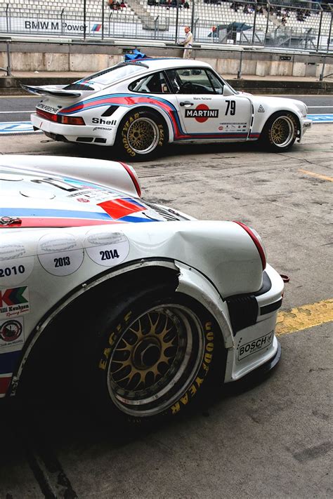 Two Racing Cars Parked Next To Each Other