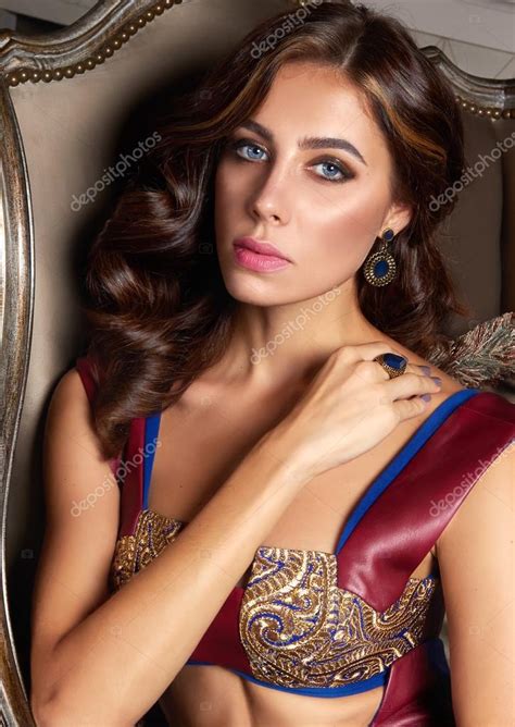 Beautiful Sexy Brunette Woman With Wavy Hair In A Bright Multi Colored Suit On The Wide Shoulder