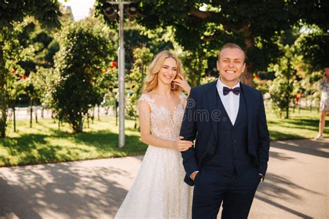 Os Pares Novos Felizes Em Seu Dia Do Casamento Passam O Tempo No Parque