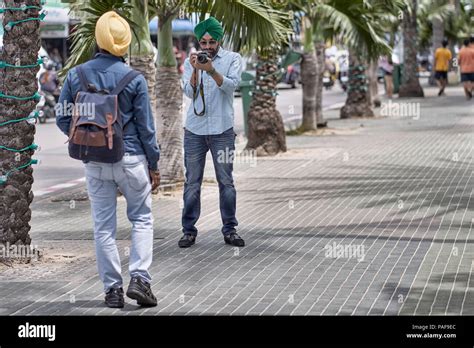 Indian Sikh Man Taking A Photograph Of His Sikh Friend On The Street