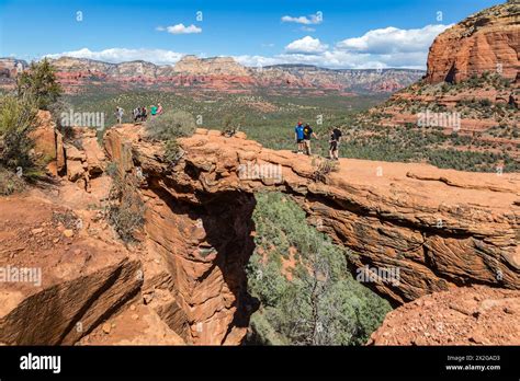 Hikers Cross The Devils Bridge Natural Arch Along The Devils Bridge