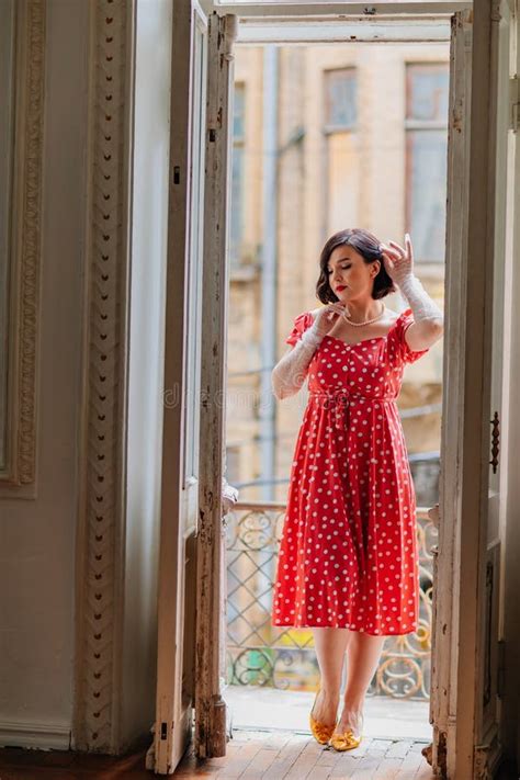 A Beautiful And Happy Brunette Women In Red Retro Dress In The Balcony Doorway Stock Photo