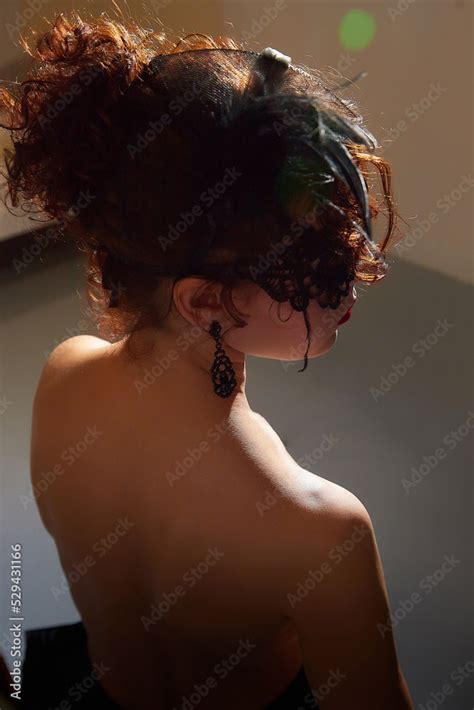 Mysterious Brunette Girl In Black Mask With Bare Back Model Posing In Studio Stock Photo