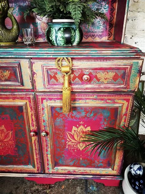 An Ornate Painted Dresser With Plants And Vases On Top