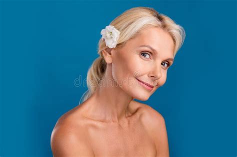 Photo Of Dreamy Shiny Senior Woman Nude Shoulders Putting Rose Flower Hairdo Isolated Blue Color