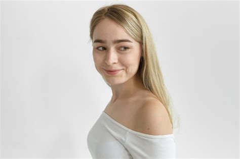 Geïsoleerde shot van gelukkige prachtige blonde vrouw met sproeten