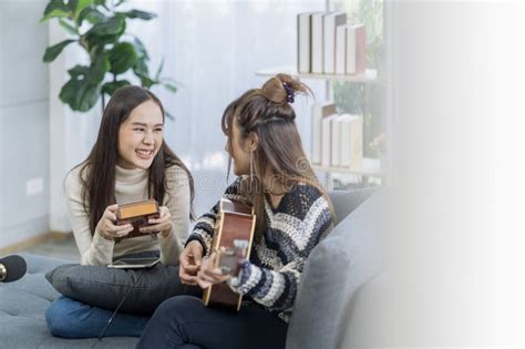 Lesbian Concept Woman Sitting On Sofa Playing Acoustic Guitar Smiling Stock Photo Image Of