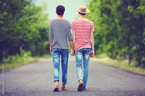 Gay Couple Walking Away Together On Spring Road Stock Photo Adobe Stock