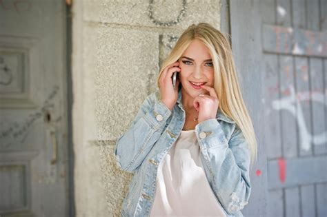 Une Fille Blonde Porte Une Veste En Jean Posée Dans La Rue Photo Gratuite