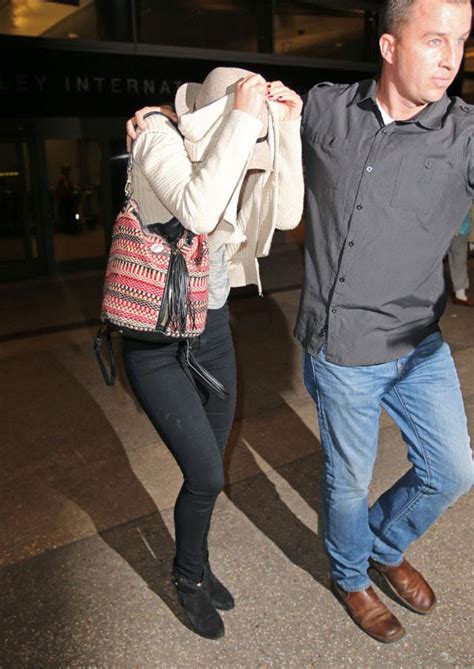 Jennifer Lawrence Takes Cover At LAX Following Nude Photo Scandal