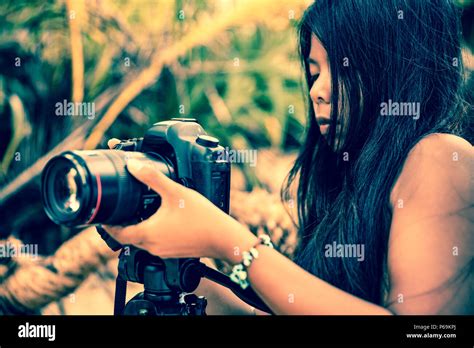 Professioneller Fotograf mit Kamera und Stativ schöne Mädchen im Bikini nimmt ein Bild von