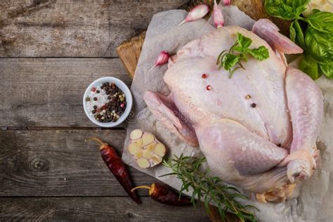 Raw Whole Chicken With Herbs And Spices On Rustic Wood Background Stock