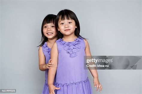 Portrait Of Smiling Twin Sisters Back To Back Photos And Premium High