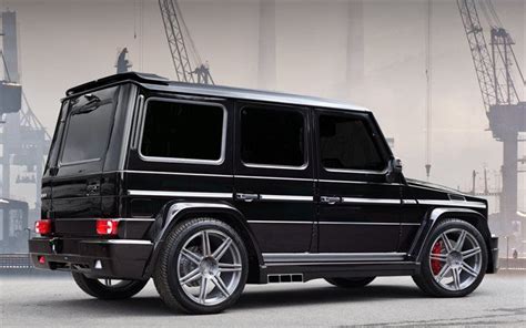 A Black Mercedes G Class Is Parked In Front Of Some Cranes