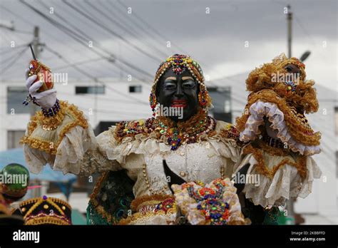 A performer dressed as the Mama Negra walks the streets during the Mama ...