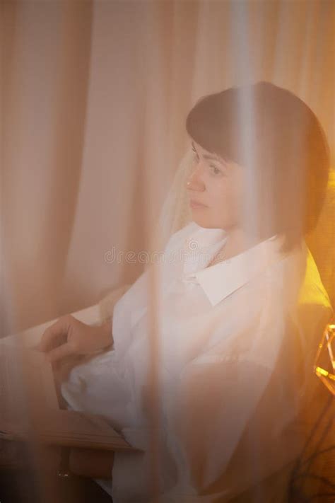 Adult Mature Woman With Book In Casual Dress White Shirt And Blue Jeans In Calm Cozy Evening