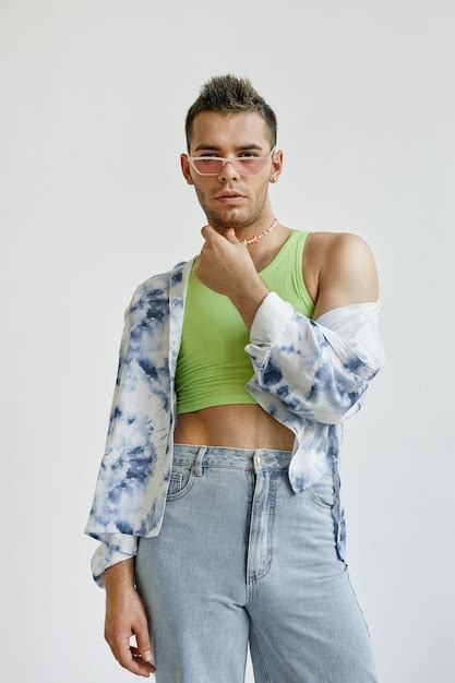 Retrato Vertical De Un Joven Gay Que Usa Un Atuendo Extravagante Con Una Blusa Corta Contra Un