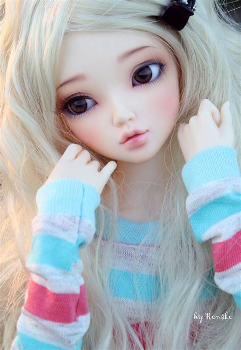 A Close Up Of A Doll With Long Blonde Hair And Blue Eyes Wearing A Striped Sweater