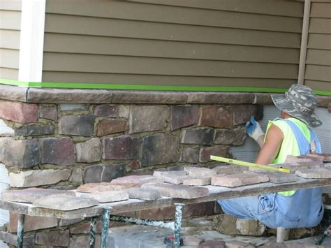 A Man Working On Some Bricks In Front Of A House