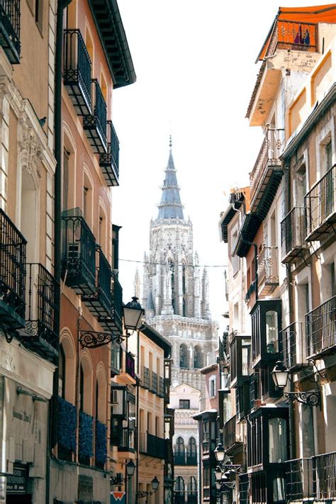 Toledo Cathedral Tower behind Buildings · Free Stock Photo